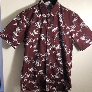 A causal button up t-shirt with leaves print.